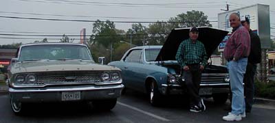 John Broussard leans against the hood of his car.