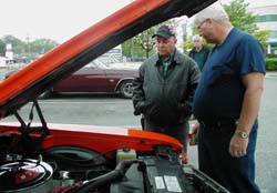 John Broussard and Ed Ronemus look under the hood of Ronemus' car.