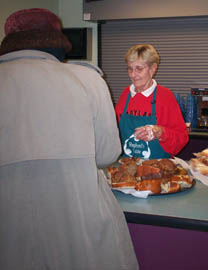 A volunteer serving food to a homeless person/Newsline photo by Raechal Leone