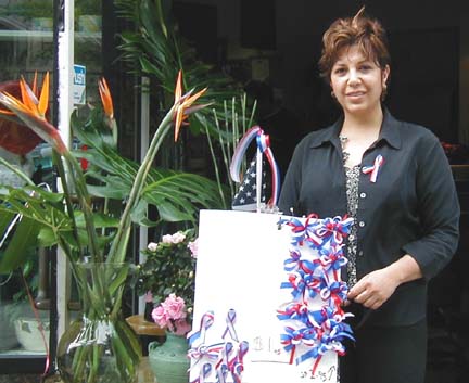 A woman sells red, white, and blue ribbons outside a flower shop at 1400 L Street.